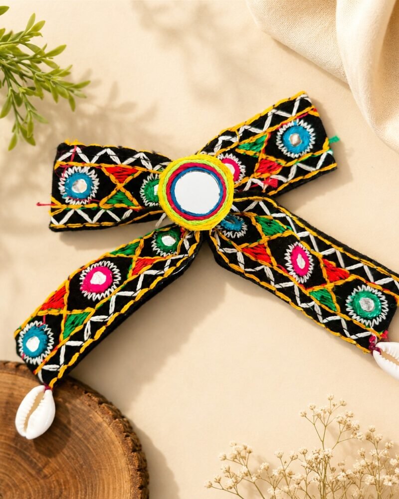 Close-up of mirror-work hair bow with cowrie shell and charm tassels