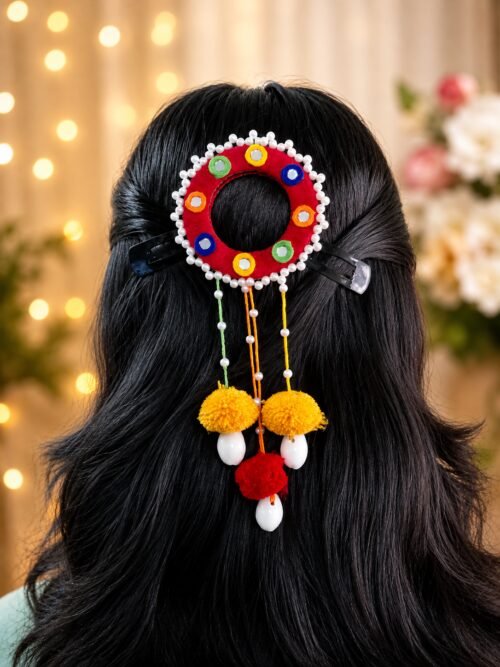 Close-up of marigold pom-pom juda pin worn in hair