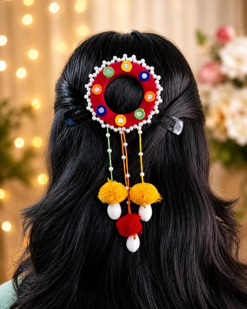 Close-up of marigold pom-pom juda pin worn in hair